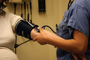 medical worker taking patient blood pressure